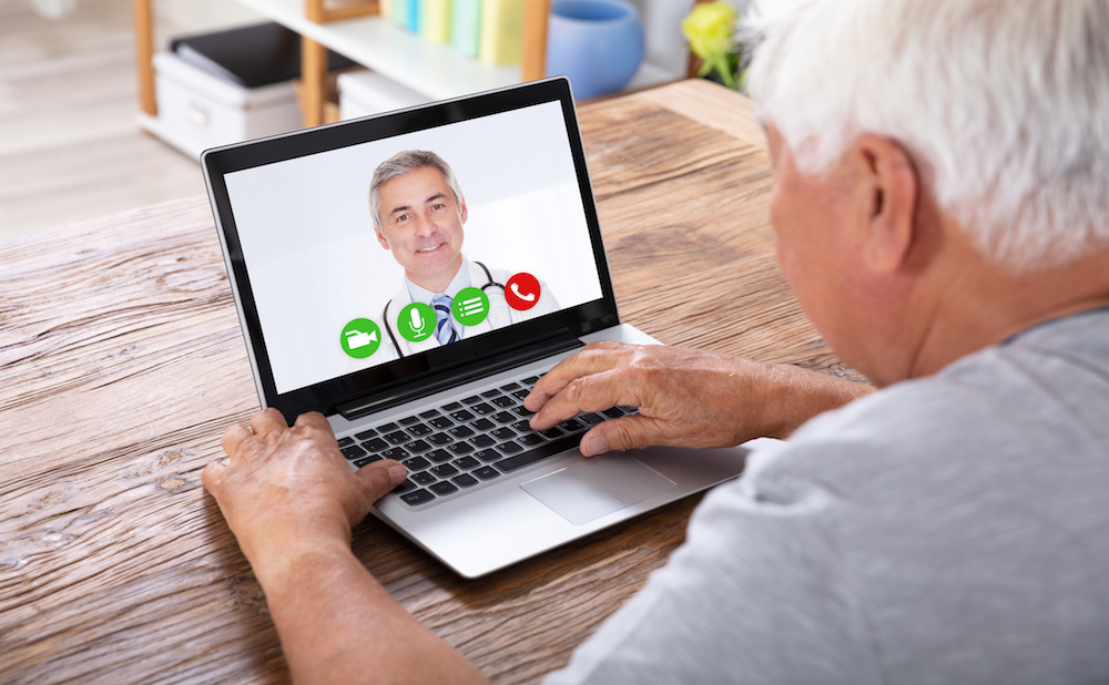 Man Video Conferencing With Doctor On Laptop